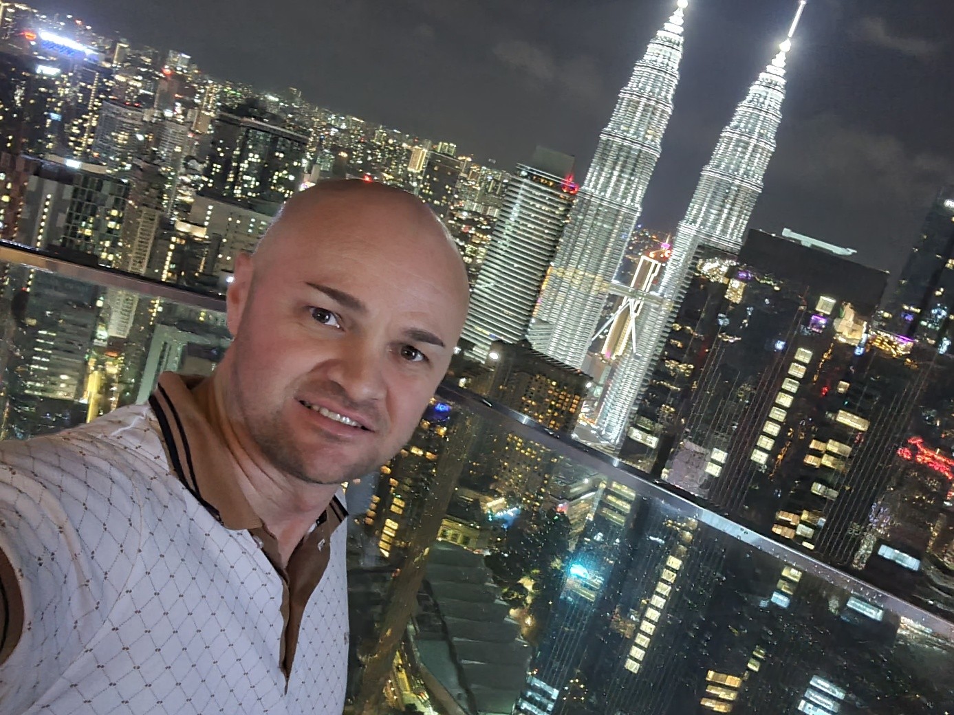 Eduard macht nachts ein Selfie mit den Petronas Towers im Hintergrund.