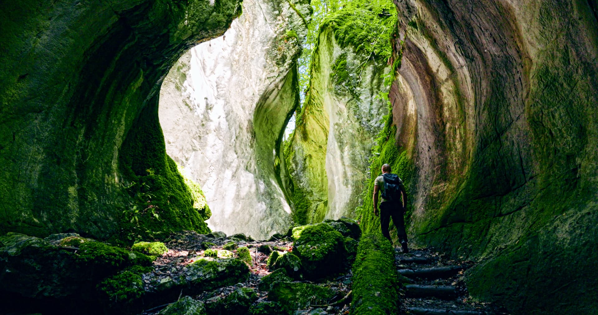 Wanderer in einer moosbewachsenen Felsschlucht