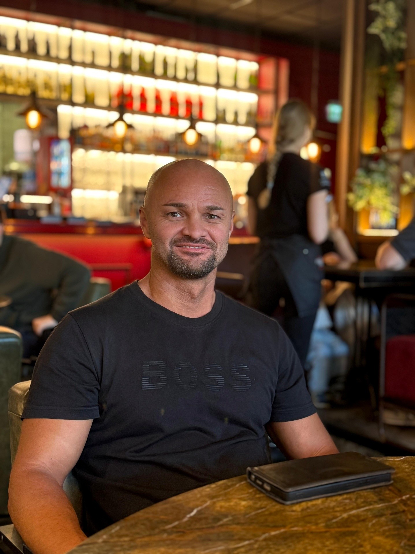 Eduard sitzt in einem Restaurant an einem Tisch.