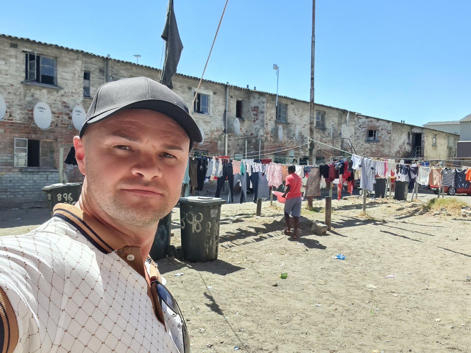 Eduard in einem Township in Kapstadt, im Hintergrund Wohnhäuser und Wäscheleinen.