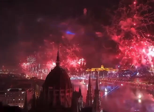 Großes rotes Feuerwerk über der Donau mit dem beleuchteten Parlamentsgebäude in Budapest.