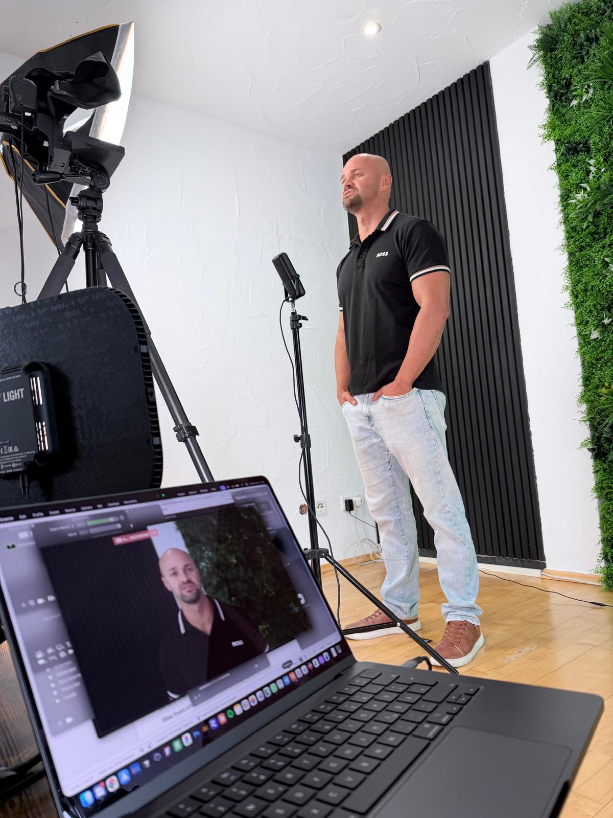Eduard steht bei Dreharbeiten im Studio vor Licht-Equipment, im Vordergrund ein Laptop mit laufender Aufnahme.